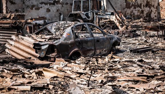 Esta fotografía tomada el 11 de mayo de 2022 muestra un automóvil y un tractor quemados después del bombardeo de las fuerzas rusas en la ciudad de Orikhiv, cerca de Zaporizhzhia, en el este de Ucrania. (Dimitar DILKOFF / AFP)