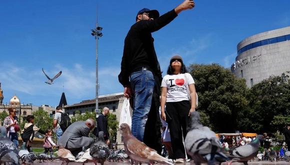 Dos turistas se fotografían en la Plaza de Cataluña de Barcelona/ AFP/Archivos