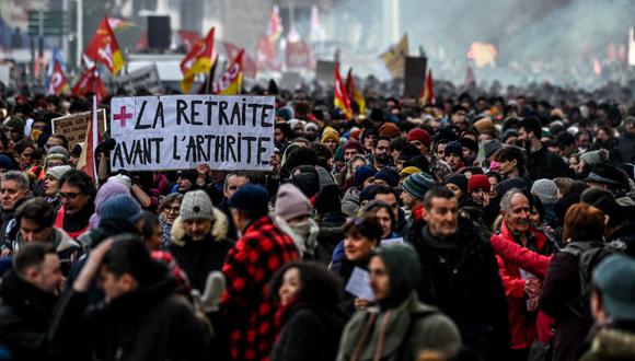 Un manifestante sostiene un cartel que dice "jubilación antes que artritis" durante una protesta en Lyon, sureste de Francia, el 19 de enero de 2023. (OLIVIER CHASSIGNOLE / AFP).