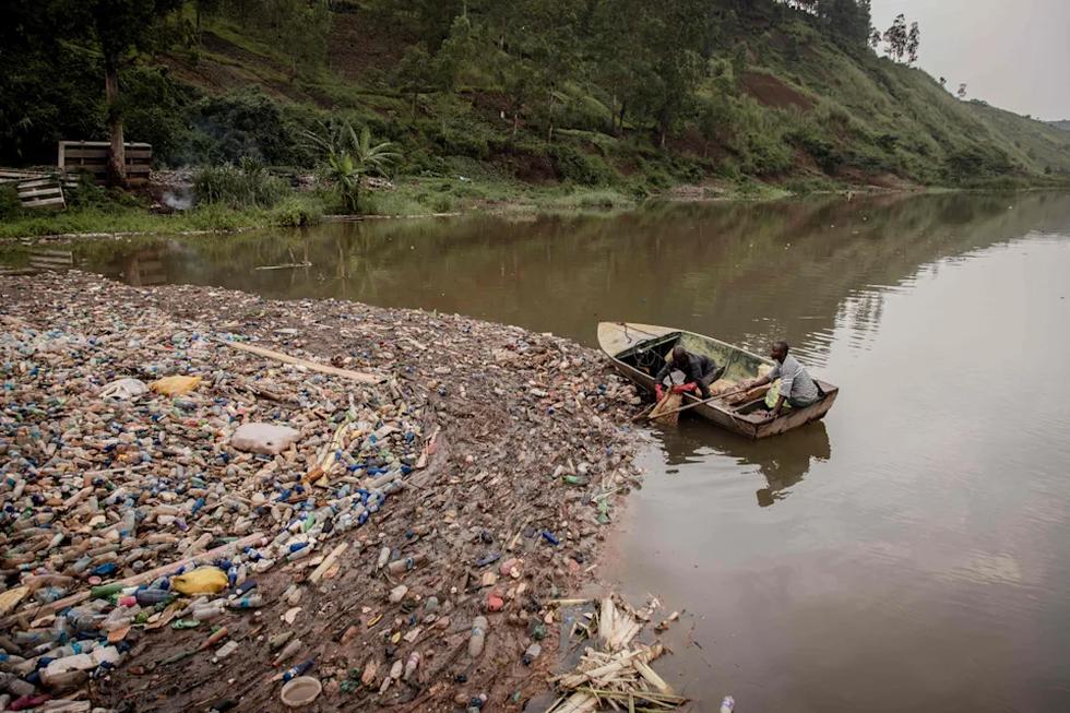 Dos trabajadores de la planta hidroeléctrica Rizizi I, la más importante del este de la República Democrática del Congo, inspeccionan las aguas del río Ruzizi, contaminadas con plásticos procedentes del lago Kivu. Los desechos están causando problemas en la central y en el suministro de energía. (Foto: Guerchom Ndebo / AFP / Getty Images).