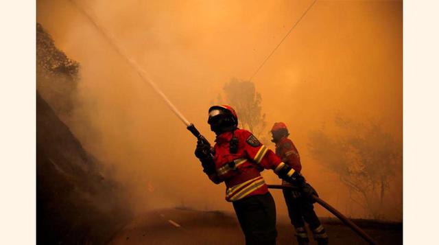 En la imagen, una pareja de bomberos intenta sofocar el incendio en el pueblo de Sandinha, cerca de Góis.