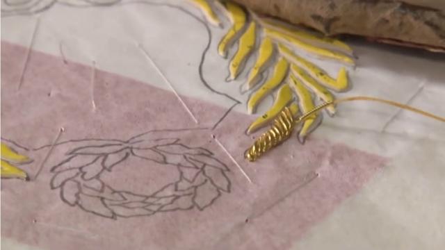 Los hilos del escudo del Perú son bordados enteramente a mano en canutillo de oro. Cada una de las líneas (que se ven en esta foto) son puestas una por una.  (Foto: Captura de pantalla de Agencia Andina)