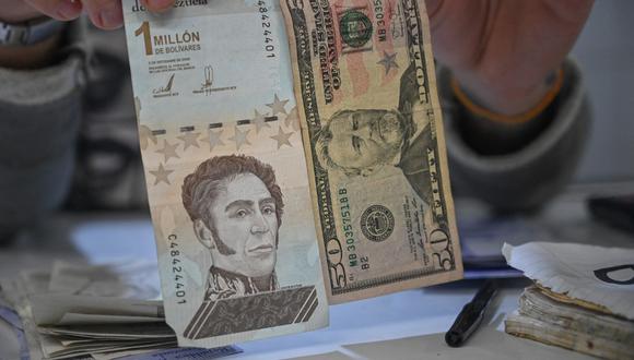 El valor de la moneda local, el bolívar, se pulverizó dando terreno al dólar, tanto que es común ver a vendedores callejeros con fajos de billetes verdes. (Foto: Federico PARRA / AFP)