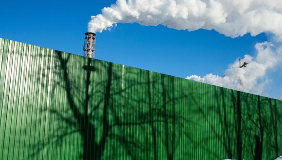 Chimneys emit vapor behind a perimeter fence with tree shadows at the Segezha Pulp and Paper Mill JSC, operated by Segezha Group, in Segezha, Russia, on Friday, March 19, 2021. Billionaire Vladimir Evtushenkov is considering an initial public offering of wood, paper and packaging producer Segezha Group after an ecommerce operator he holds a stake in notched the most successful Russian debut in nearly a decade last November.