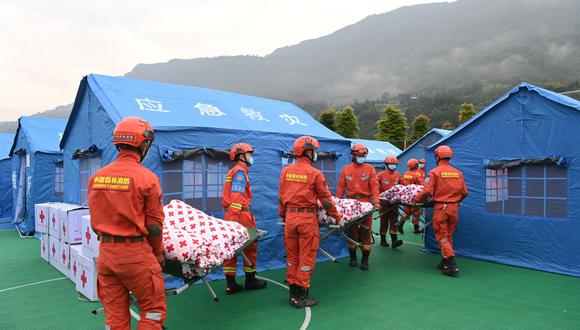 Los equipos de rescate transfieren suministros cerca de las tiendas de campaña instaladas para las personas desplazadas después de un terremoto de magnitud 6,1 en Yaan, en la provincia suroccidental china de Sichuan. (Foto por CNS / AFP) / China FUERA