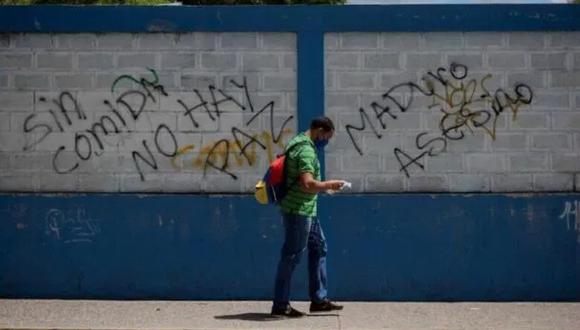 Un hombre camina frente a un grafitis con mensaje en rechazo al presidente de Venezuela, Nicolás Maduro. Si Maduro carga a sus espaldas con señalamientos nacionales e internacionales de violación sistemática de los derechos humanos, a Guaidó lo persigue la sombra de operaciones poco ortodoxas para acabar con el Gobierno. (Foto: EFE/Rayner Peña)