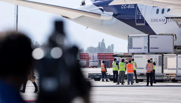 Operarios aeroportuarios descargan el contenedor con las aproximadamente dos millones de vacunas del laboratorio chino Sinovac que llegaron al Aeropuerto Internacional Arturo Merino Benítez, en Santiago (Chile). (EFE/ Alberto Valdes).