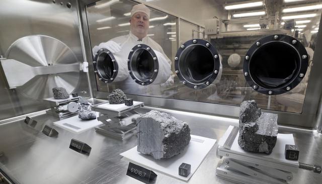 FOTO 3 | muestras de roca lunar selladas desde las misiones Apolo
Ryan Zeigler, curador de las muestras del Apolo, a la izquierda, de pie al lado de la caja presurizada nitrógeno en el que se exhiben varias muestras lunares recolectadas durante las misiones Apolo 15, 16 y 17, dentro del laboratorio lunar del Centro Espacial Johnson de la NASA, en Houston, en una foto del 17 de junio de 2019 (Foto: Michael Wyke/AP).