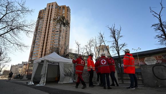Los médicos se reúnen junto a un bloque de apartamentos de gran altura que fue alcanzado por un bombardeo reciente en Kiev el 26 de febrero de 2022. (Foto: GENYA SAVILOV / AFP)