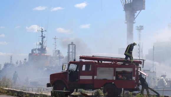 Los bomberos ucranianos luchando contra un incendio en un barco que arde en el puerto de Odessa después de que los misiles rusos impactaran en el puerto el 23 de julio de 2022. (Foto del canal de Telegram del Ayuntamiento de Odessa / AFP).