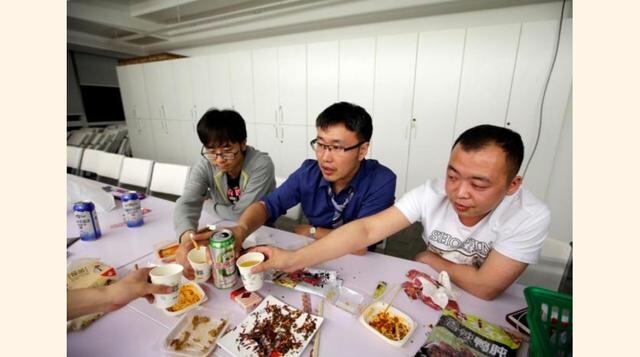 Han Liqun (en el centro), un gerente de Recursos Humanos de RenRen Credit Management Co., toma unas bebidas con sus colegas Kou Meng (a la izq.) y Ma Zhenguo al finalizar su trabajo después de la medianoche en Pekín, China. (Foto: Reuters)