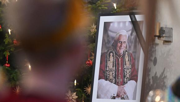 Una fotografía del ex Papa emérito Benedicto XVI se ve durante un culto en la iglesia católica St Oswald en su lugar de nacimiento Marktl, en el sur de Alemania, el 31 de diciembre de 2022. (Foto de KERSTIN JOENSSON / AFP)