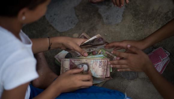 A pesar del nuevo nombre, que sustituyó al anterior de bolívar soberano, la nueva moneda no es digital, ya que cuenta con billetes y monedas.. (Photo by Federico PARRA / AFP)