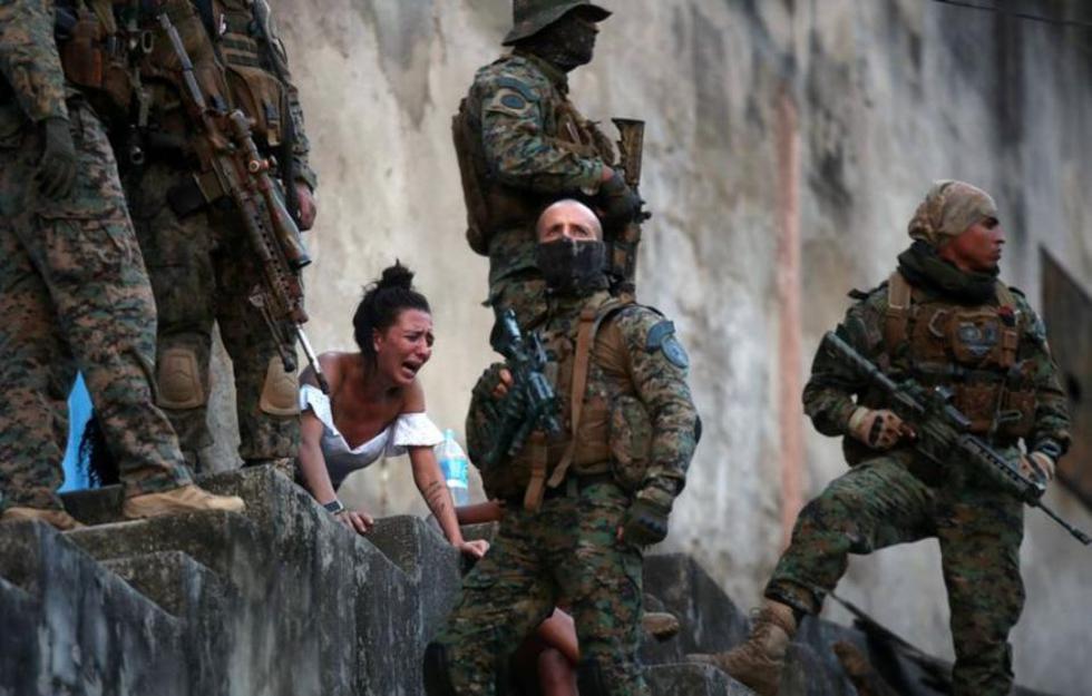 Una mujer llora junto al cuerpo de un hombre que recibió un disparo en la favela de Sao Carlos de Río de Janeiro (Brasil) el 27 de agosto durante un enfrentamiento entre bandas de narcotraficantes. (Foto: Ricardo Moraes / Reuters).