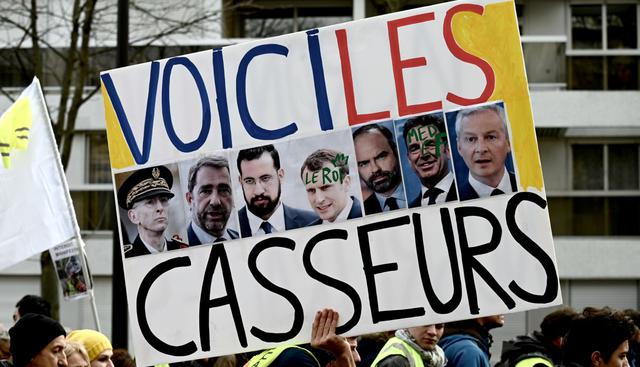 El activista francés Jean-Baptiste Redde, también conocido como Voltuan, sostiene una pancarta que dice "aquí están los destructores". (Foto: AFP)