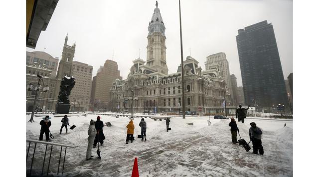 Trabajadores retiran la nieve acumulada frente al edificio del servicio municipal en Filadelfia. (Foto: Philadelphia Daily News vía AP)