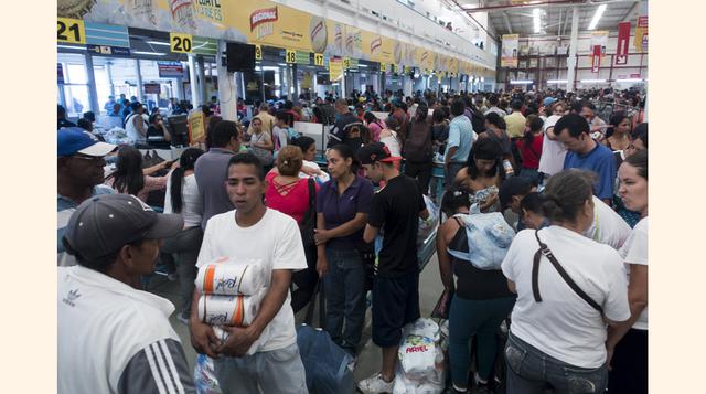 Cientos de venezolanos hacen largas colas para pagar sus productos en un supermercado Makro en Caracas. Los supermercados en Venezuela son cada vez más el blanco de saqueadores, en tanto largas colas y la prolongada escasez de alimentos causa frustración 