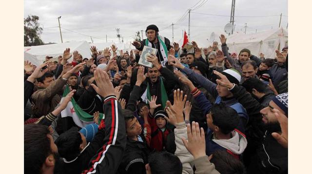 Refugiados sirios muestran una copia del Corán.(foto:Diario ABC, S.L.)