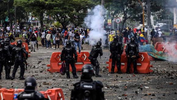 Manifestantes chocan con la policía antidisturbios durante una protesta contra un proyecto de reforma tributaria lanzado por el presidente colombiano Iván Duque, en Cali, Colombia. (AFP / Paola MAFLA).