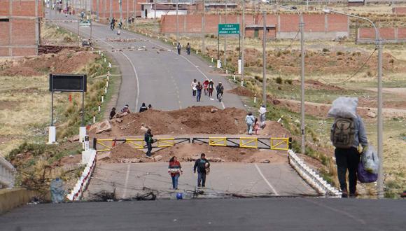 Personas caminan por una calle bloqueada, el 17 de enero de 2023, en el lado peruano de la población de Desaguadero, en la frontera con Bolivia. (Foto referencial de Javier Mamani / EFE)
