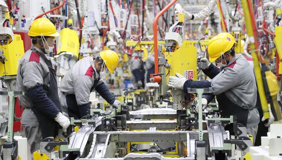 Empleados trabajan en una línea de ensamblaje de automóviles en una fábrica de Beijing Automotive en Qingdao, en la provincia oriental china de Shandong. (Foto por AFP)