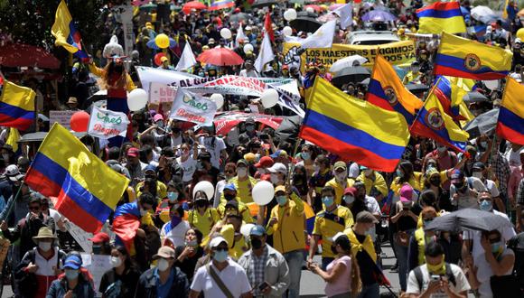 La gente sostiene banderas colombianas mientras participa en una nueva protesta contra el gobierno del presidente Iván Duque en Bogotá. (Foto de Raúl ARBOLEDA / AFP).
