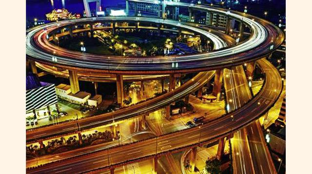 NANPU (SHANGHAI), Una de las dos entradas del puente de Nanpu, que cruza el río Huangpu, en Shanghái, está estructurado en forma circular. La ausencia de espacio que permitiera construir una pendiente lo suficientemente suave para salvar el desnivel oblig