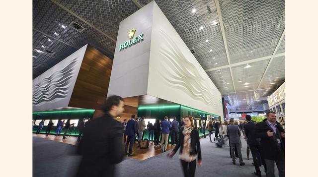 Varios asistentes a Baselworld caminan cerca del stand del fabricante suizo de relojes Rolex instalado en la mayor feria anual de la industria relojera en Basilea. (Foto: AFP)