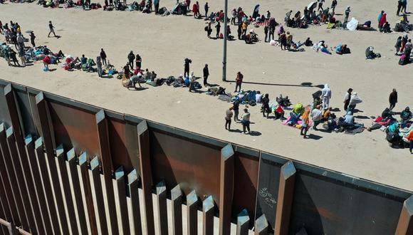 Migrantes esperando a lo largo del muro fronterizo entre Estados Unidos y México en El Paso, Texas, el 11 de mayo de 2023. (Foto de Patrick T. Fallon / AFP)