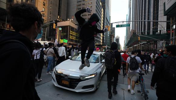 Un manifestante salta sobre un carro durante una protesta en Nueva York por el asesinato de George Floyd. (Foto: AFP)