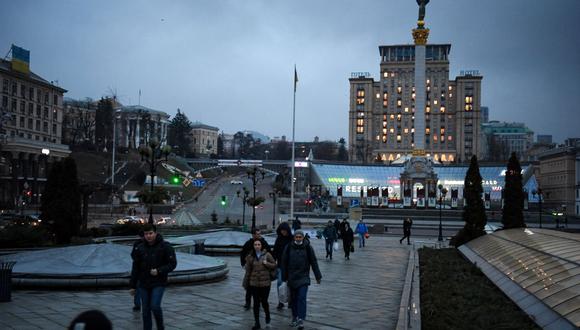 La gente camina en el centro de Kiev frente al Monumento a la Independencia a primera hora del 24 de febrero de 2022. (Foto de Daniel LEAL / AFP)