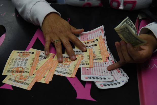 A customer picks up his California Powerball lottery ticket from the famous Bluebird liquor store, considered a lucky ticket retailer, in Hawthorne, California, January 13, 2016 (Photo: Mark Ralston/AFP)