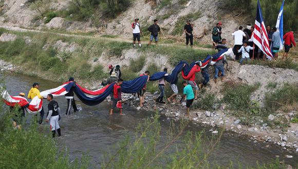 Migrantes venezolanos cruzan el río Bravo para realizar una manifestación contra las políticas migratorias de EE.UU. en Ciudad Juárez, México, el 31 de octubre de 2022. (Foto de HERIKA MARTINEZ / AFP)