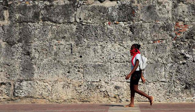 Una joven camina por la cera de una muralla en Cartagena (Colombia). El aislamiento social obligatorio por coronavirus es una medida drástica que ha sido tomada por varios países del mundo. (EFE/ Ricardo Maldonado Rozo).