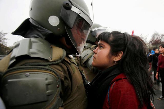 Durante una manifestación en Santiago de Chile, por el 43 aniversario del golpe de Estado, está chica se encaró a un policía. El cruce de miradas hizo que el momento diera la vuelta al mundo. (Foto Reuters)