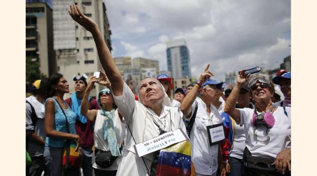 Una monja frente a un cordón de la Guardia Nacional Bolivariana que bloquea el paso a la marcha de mujeres de la oposición, en una carretera en Caracas, el 6 de mayo de 2017.(foto: Ariana Cubillos).