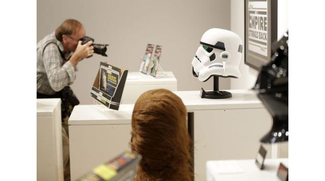 Un reportero gráfico toma fotografías de juguetes y otros objetos de interés de la serie de películas &#039;Star Wars&#039; durante la presentación a la prensa que organizó Sotheby’s, en Nueva York, para anunciar la celebración de una subasta en línea de 