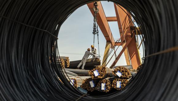 Los trabajadores se preparan para levantar un paquete de barras de refuerzo de acero con una grúa pórtico en un depósito de metal en Shanghai, China, el lunes 7 de junio de 2021. Fotógrafo: Qilai Shen/Bloomberg