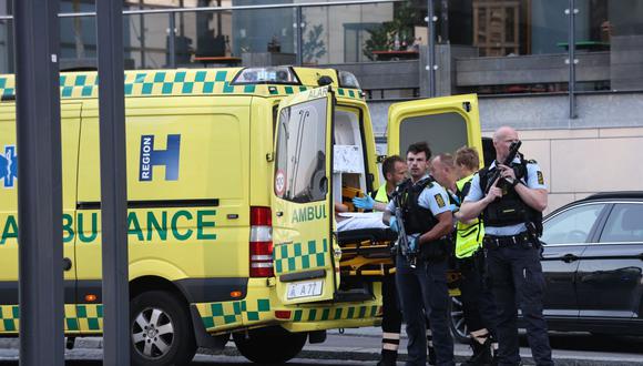 Una ambulancia y policías armados durante la evacuación de personas heridas en el centro comercial Fields en Copenhague, Dinamarca, el 3 de julio de 2022. (Foto: OLAFUR STEINAR GESTSSON / RITZAU SCANPIX / AFP).