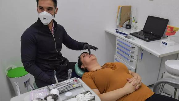 El odontólogo Thiago Aragaki hace un tratamiento facial con ácido hialurónico a su paciente, Rita Meireles, en Sao Paulo, Brasil. (Foto: NELSON ALMEIDA AFP)