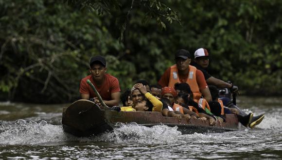 Migrantes venezolanos son vistos durante su viaje en una piragua a Meteti a través del río Chucunaque desde el pueblo de Canaan Membrillo, el primer control fronterizo de la provincia de Darién en Panamá, el 12 de octubre de 2022. (Foto por Luis ACOSTA / AFP)