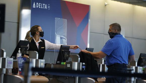 Imagen de archivo del 22 de julio de 2020, personal de Delta Airlines entrega a un pasajero un pase de abordaje en la terminal principal del Aeropuerto Internacional de Denver. (Foto: AP/ David Zalubowski)