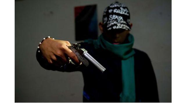 Cali, Colombia. Homicidios: 1.530. Población: 2.344.734. Tasa de homicidios: 65.25. En la imagen: Un integrante de una banda criminal posa con un arma casera en el vecindario de Siloe, en Cali.