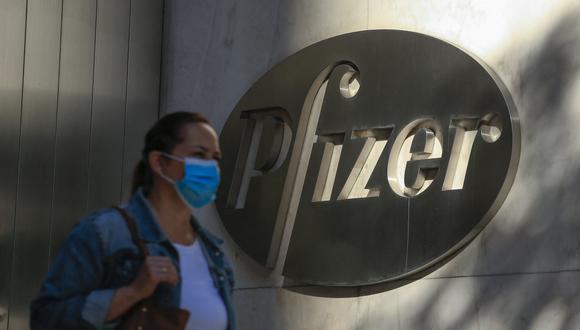 Una mujer usa una máscara facial mientras camina por la sede mundial de Pfizer en Nueva York el 9 de noviembre de 2020. (Foto: Kena Betancur / AFP)