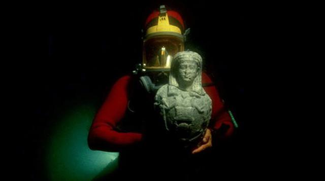 Los objetos encontrados bajo el mar revelan historias sobre la política y cultura de estas civilizaciones, y permiten conocer más sobre sus dioses y reyes. En la imagen, un buzo muestra una estatua de mármol del dios Osiris hallada en Canopus. Data de los