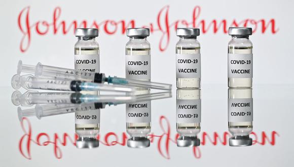 En esta ilustración tomada el 9 de febrero de 2021, se ven viales etiquetados como "Vacuna contra el coronavirus COVID-19" delante del logotipo de Johnson & Johnson. (Foto: Justin Tallis / AFP)