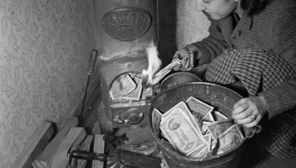 Una mujer enciende un fuego con billetes húngaros (Pengos), en enero de 1946 en Budapest, durante la crisis inflacionaria que vivió Hungría entre agosto de 1945 y julio de 1946. (Foto de Louis FOUCHERAND / AFP)