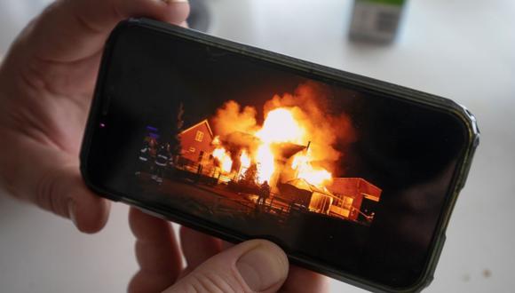 Henri Seepers muestra una fotografía de su antigua casa en llamas tras el incendio provocado. Fotógrafo: Peter Boer/Bloomberg