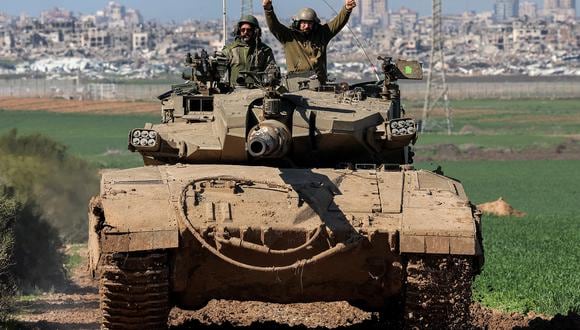 Un soldado del ejército israelí hace gestos mientras está sentado en la torre de un tanque de batalla que se mueve en una posición a lo largo de la frontera entre el sur de Israel y la Franja de Gaza el 31 de enero de 2024 en medio del conflicto en curso entre Israel y el grupo militante palestino Hamás. (Foto de JACK GUEZ / AFP)