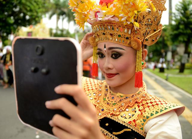 FOTO 12 | Jóvenes de Bali se preparan para participar en un desfile cultural de un festival para celebrar el Año Nuevo en Denpasar.